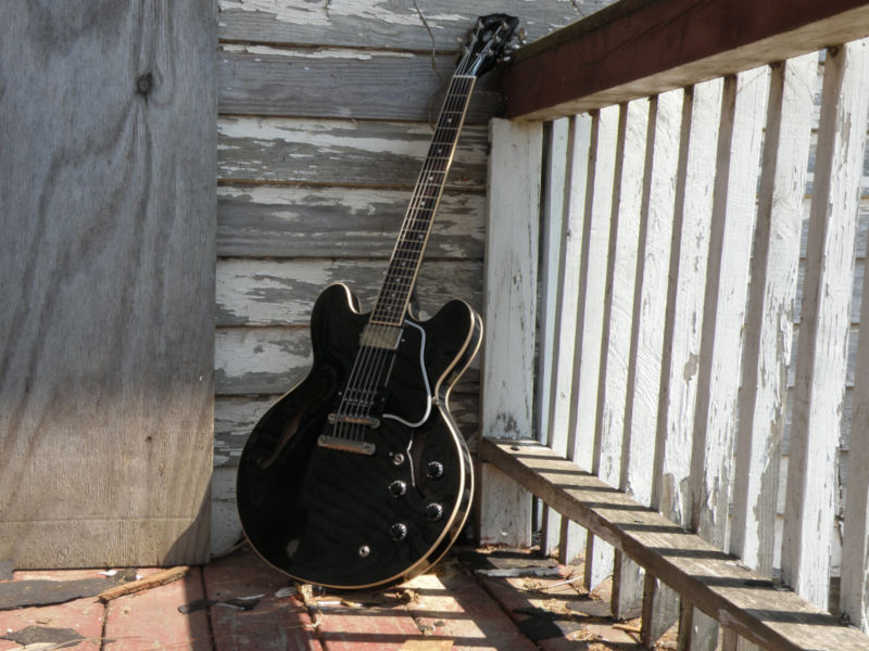 Guitar propped up in corner railing